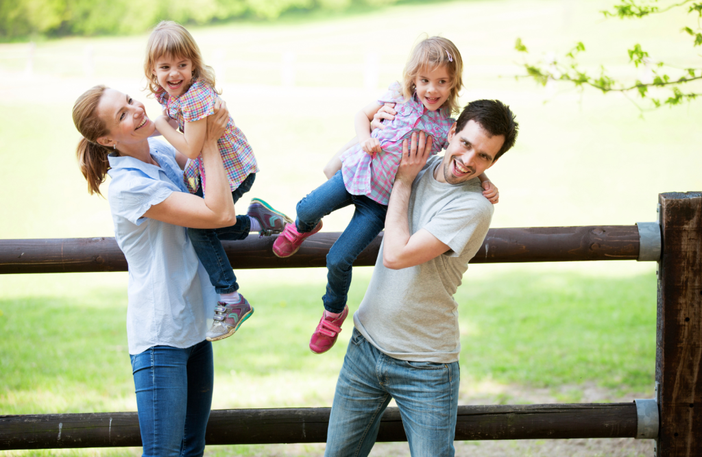 Mutter und Vater mit jeweils einer ihrer Zwillingstöchter